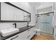 Modern bathroom featuring double sinks, a large mirror, and a glass-enclosed shower with modern fixtures at 12055 E Clinton St, Scottsdale, AZ 85259