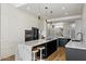 Modern kitchen with white cabinets, black island with marble countertop, and pendant lighting at 12055 E Clinton St, Scottsdale, AZ 85259