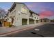 Multi-level home featuring a private garage, neutral stucco facade, and a small balcony under a twilight sky at 1330 S Aaron -- # 218, Mesa, AZ 85209