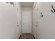 Hallway featuring clean white walls, multiple doors with brass hardware, coat hooks, and wood-look flooring at 1330 S Aaron -- # 218, Mesa, AZ 85209