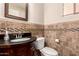 Elegant bathroom features a granite countertop vanity, decorative mirror, and tiled walls at 13514 W Banff Ln, Surprise, AZ 85379