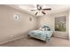 Cozy bedroom with neutral colors, multiple windows, and a ceiling fan at 13514 W Banff Ln, Surprise, AZ 85379