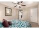 Comfortable bedroom with carpeted floors, ceiling fan, and a desert-themed wall painting at 13514 W Banff Ln, Surprise, AZ 85379