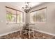 Cozy dining area with a round table, chandelier, and natural light from the windows at 13514 W Banff Ln, Surprise, AZ 85379