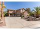 Charming two-story home with a spacious three-car garage, a large driveway and mature palm trees at 13514 W Banff Ln, Surprise, AZ 85379