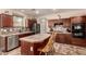 Stylish kitchen featuring a central island with seating, dark wood cabinets and granite countertops at 13514 W Banff Ln, Surprise, AZ 85379