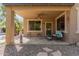 Covered patio with comfortable seating and a view of the well-manicured backyard at 13514 W Banff Ln, Surprise, AZ 85379
