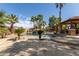 Luxurious backyard pool with a rock waterfall feature, poolside gazebo, and palm trees at 13514 W Banff Ln, Surprise, AZ 85379