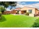 A spacious backyard with artificial turf, a covered patio, and desert landscaping provides a private retreat at 1437 E Flamingo Way, Gilbert, AZ 85297