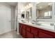 Bathroom with dual vessel sinks, red cabinets, and modern fixtures and neutral flooring at 1439 S Dodge St, Gilbert, AZ 85233