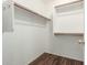 Empty closet with dark floors and built-in shelving and clothing rods at 1439 S Dodge St, Gilbert, AZ 85233
