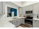 Updated kitchen with stainless steel appliances, quartz countertops, and view into the living area at 1439 S Dodge St, Gilbert, AZ 85233