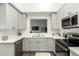 Well-lit kitchen with stainless steel appliances, white backsplash, and gray cabinetry at 1439 S Dodge St, Gilbert, AZ 85233