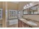 Bathroom features a double vanity, a tub, and plantation shutters providing natural light and privacy at 15206 S 47Th St, Phoenix, AZ 85044