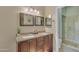 Bathroom features a double vanity with a stone countertop, framed mirrors, and a glass door shower at 15206 S 47Th St, Phoenix, AZ 85044