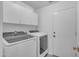Modern laundry room with front-loading washer and dryer, and storage cabinets at 15206 S 47Th St, Phoenix, AZ 85044