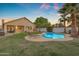 This backyard has a refreshing pool, green grass and mature palm trees at 15206 S 47Th St, Phoenix, AZ 85044