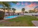Backyard oasis features a pool, green grass and multiple seating areas at 15206 S 47Th St, Phoenix, AZ 85044