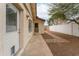 Sideyard view of home showing the back entrance, brick pathway, and desert landscaping at 1523 W Glenn Dr, Phoenix, AZ 85021