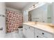 Classic bathroom features a vanity with cabinets, a large mirror, and a shower with a floral curtain at 1523 W Glenn Dr, Phoenix, AZ 85021