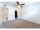 Bright, unfurnished bedroom with ceiling fan, closet, and neutral carpet at 1523 W Glenn Dr, Phoenix, AZ 85021