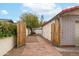 Exterior view showcasing brick pathway and wooden gate leading to storage shed at 1523 W Glenn Dr, Phoenix, AZ 85021