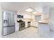 A well-lit kitchen with stainless steel appliances, white cabinetry, and tile flooring at 1523 W Glenn Dr, Phoenix, AZ 85021