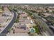 Overhead view reveals a community with homes, showcasing one residence with a pool, lawn, and solar panels at 18051 W Port Royale Ln, Surprise, AZ 85388