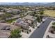 Stunning aerial view of a desert home with a tile roof, solar panels, and a manicured lawn at 18051 W Port Royale Ln, Surprise, AZ 85388