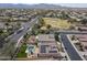 This aerial image features a community with a home that has a refreshing pool and solar panels, near a park at 18051 W Port Royale Ln, Surprise, AZ 85388