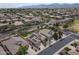 Wide aerial shot showcases a neighborhood with modern homes equipped with solar panels, plus a park and mountain views at 18051 W Port Royale Ln, Surprise, AZ 85388