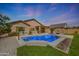 Inviting backyard with a sparkling pool, covered patio, and well-maintained landscaping at 18051 W Port Royale Ln, Surprise, AZ 85388