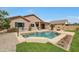 Inviting backyard featuring a sparkling pool, lush lawn, desert landscaping, and a patio area at 18051 W Port Royale Ln, Surprise, AZ 85388