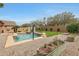 Backyard with a swimming pool, basketball hoop, desert landscaping, and green lawn at 18051 W Port Royale Ln, Surprise, AZ 85388