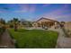 Lush backyard featuring a pool, desert landscaping, a fire pit, and a covered patio at 18051 W Port Royale Ln, Surprise, AZ 85388