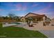 Beautiful backyard featuring a pool, built-in grill, outdoor fireplace, and well-maintained landscaping at 18051 W Port Royale Ln, Surprise, AZ 85388