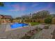 Private backyard featuring a shimmering pool, mature trees, and ample space for outdoor enjoyment at 18051 W Port Royale Ln, Surprise, AZ 85388