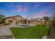 Spacious backyard featuring desert landscaping, a sparkling pool, and lush green grass at 18051 W Port Royale Ln, Surprise, AZ 85388