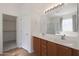 Bathroom with double sinks and a walk-in closet for added convenience at 18051 W Port Royale Ln, Surprise, AZ 85388