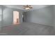 Large bedroom with plush carpet, ceiling fan and access to the bathroom at 18051 W Port Royale Ln, Surprise, AZ 85388