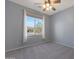 Bright bedroom with a ceiling fan and a large window offering a view of the neighborhood at 18051 W Port Royale Ln, Surprise, AZ 85388