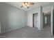 Light and airy bedroom with a ceiling fan, soft carpet, and closet for storage at 18051 W Port Royale Ln, Surprise, AZ 85388