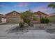 Charming single-story home featuring desert landscaping, a two-car garage, and a welcoming facade at 18051 W Port Royale Ln, Surprise, AZ 85388