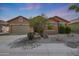 Charming single-story home featuring desert landscaping, a two-car garage, and a welcoming facade at 18051 W Port Royale Ln, Surprise, AZ 85388