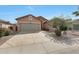 Single-story home with low maintenance desert landscaping and a paved driveway leading to an attached two car garage at 18051 W Port Royale Ln, Surprise, AZ 85388