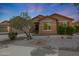 Charming single-story home featuring desert landscaping, a two-car garage, and a welcoming facade at 18051 W Port Royale Ln, Surprise, AZ 85388