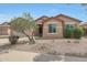 Charming single-story home featuring a low-maintenance desert landscaped front yard and attached two car garage at 18051 W Port Royale Ln, Surprise, AZ 85388