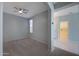 Open living area with carpet, a ceiling fan, and a view into the hall that has access to the laundry room at 18051 W Port Royale Ln, Surprise, AZ 85388
