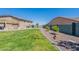 Green backyard featuring a pergola patio and a desert-landscaped border at 18159 W Piro St, Goodyear, AZ 85338
