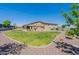 Large backyard with a lush green lawn, desert landscaping, and a patio at 18159 W Piro St, Goodyear, AZ 85338